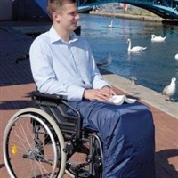 Man sitting in wheelchair with scooter leg cape on