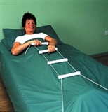 Person laying in bed using rope ladder to sit up